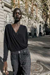 Jeans de tiro alto, corte recto y largo, color negro lavado, con abalorios brillantes distribuidos por toda la prenda.