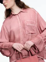 Camisa gris de manga larga confeccionada en viscosa teñida en frío, con efecto gastado. De corte relajado, con bolsillo delantero y puños amplios.