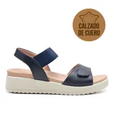 Sandalias de cuero azul marino con plataforma baja color beige. Presentan dos tiras ajustables con velcro y plantilla acolchada.