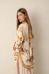 Blusa color crema con estampado floral y detalles de diseño barroco, con cuello mao, mangas 3/4 y cierre frontal con botones.