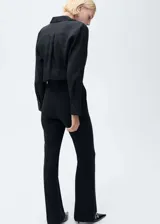 Camisa celeste de lino con cuello camisero, manga larga con puños abotonados y cierre frontal con botones.