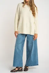 Sweater color beige de tejido texturado, con cuello redondo y mangas largas.