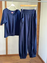 Conjunto de dos piezas color azul marino, compuesto por una remera de manga tres cuartos con escote en V y una babucha de tiro alto con bolsillos laterales y puños elastizados.