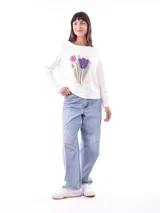 Remera color verde claro con estampado de flores blancas y hojas verdes en el frente.