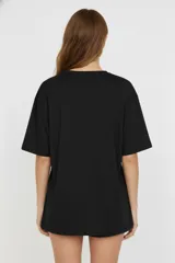 Remera negra de algodón, manga corta, corte ancho y cuello redondo.