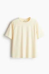 Remera deportiva color crema de tejido funcional con tecnología DryMove™, corte holgado, cuello redondo y mangas cortas raglán.