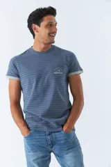 Remera de hombre a rayas horizontales en tonos de azul, con bolsillo en el pecho y mangas cortas con puños grises.