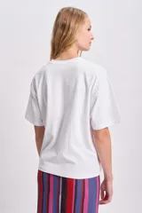 Remera blanca de corte boxy con estampa roja de la palabra "Bonjour" en el frente.
