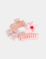 Set de cuatro broches para el pelo en diferentes formatos y tamaños, con diseños de flores y colores pastel.
