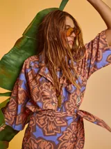 Camisa oversize de algodón con estampado abstracto en tonos marrón, naranja y celeste. Tiene cuello clásico, cierre frontal con botones y mangas cortas.