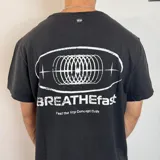 Remera blanca de corte clásico con estampado en la espalda que incluye un óvalo con diseño abstracto y la frase "BREATHEfast Feel the Vcp Concept Drift".