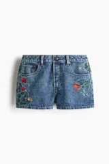 Short de jean de tiro alto con bordados de flores rojas, amarillas y blancas.
