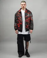 Campera reversible negra con un lado estampado y otro liso, confeccionada en textil impermeable. Corte amplio, talle Super XL.