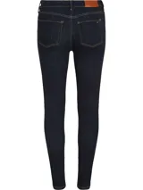 Pantalón de jean azul oscuro, corte skinny, tiro alto y largo hasta el tobillo.