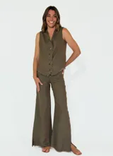 Chaleco beige de lino con escote en V, cierre frontal con botones y terminaciones desflecadas.