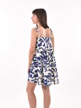 Vestido corto con estampado abstracto en tonos azul y blanco, con breteles finos y falda con volados.