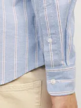 Camisa de vestir de manga larga a rayas verticales celestes y blancas, con cuello abotonado y corte slim fit.