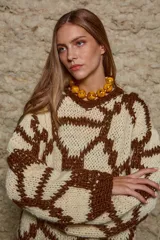 Sweater de lana tejido a mano con diseño geométrico en tonos marrón y beige, de calce holgado, cuello redondo y puños ajustados.