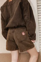 Bermuda de jean color marrón con efecto desgastado, tiro medio y corte holgado.