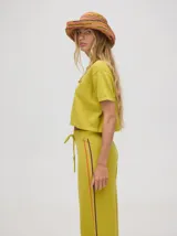Pantalón de algodón negro, corte holgado y pierna ancha con pretina elástica. Presenta rayas bicolor al costado en blanco y celeste. Calce de tiro alto.