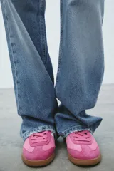 Zapatillas deportivas rosas de gamuza con detalles en blanco y suela marrón.