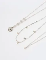 Set de tres collares cortos plateados con dijes de estrellas y constelaciones.
