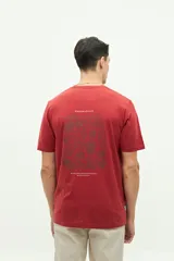 Remera azul con estampado de conchas marinas en la espalda y logo de la marca en la parte superior.