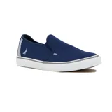 Zapatilla tipo slip-on de lona color azul marino, con suela de goma blanca y detalles en gris. Presenta un logo de velero en el talón y un detalle de costura ondulada en el empeine.