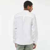 Camisa blanca de lino de corte regular, con cuello clásico, manga larga con puños abotonados y cierre frontal con botones.