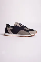 Zapatillas casuales para hombre con suela de goma, diseño en tonos beige y negro, con logo en relieve.