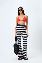 Pantalón tejido con motivo zigzag en tonos beige y blanco, de corte flare y cintura elastizada.