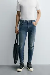 Pantalón de jean color beige, corte skinny, tiro medio, largo cropped y cinco bolsillos.