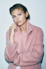 Abrigo amplio color rosa, confeccionado en hilatura con lana y alpaca. Tiene cuello solapa, manga larga, forro interior y cierre frontal con gancho metálico.