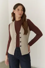 Chaleco tejido color beige con cuello en V y cierre frontal con botones.