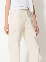 Pantalón color crema de corte slouchy con pinzas en las rodillas y bordados de hongos y chiles con strass.