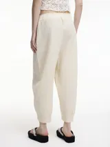 Pantalón tipo chino color crudo, con bolsillos laterales y pretina elástica. Textura arrugada.