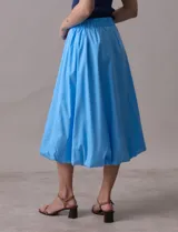 Falda midi color amarillo pálido, de algodón, con pretina ancha elastizada y forro interno a tono.