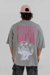 Remera gris de corte holgado con estampa en la espalda con la frase 'Mentally Gone' en rosa y un rostro abstracto en blanco.