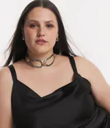 Vestido midi de tela satinada color negro, con escote drapeado, breteles medianos, cintura ajustada y pollera cruzada.