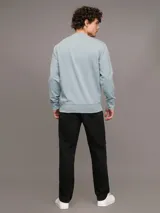 Buzo celeste de cuello redondo, marca Calvin Klein, con logo CK bordado en el pecho.