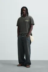 Camiseta negra con efecto lavado, cuello redondo, manga corta y estampado en el frente con la frase "Don't miss out! One Night. One Stage.".