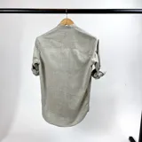 Camisa de cuello mao en algodón de color verde claro, con cierre frontal y mangas largas.