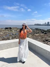 Top tejido al crochet color naranja, con tirantes finos y cierre frontal con lazos.