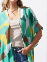 Kimono tejido con estampado geométrico en tonos verde, amarillo y marrón. Tiene mangas amplias estilo japonés y terminación de ruedo con borlas.