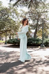 Top celeste con lurex, escote cruzado y mangas anchas acampanadas.