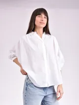 Camisa celeste con cuello mao, corte holgado, mangas 3/4 abullonadas con puños elásticos y cierre frontal con botones.