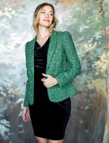 Blazer en tejido tweed, color verde, con cuello solapa, abertura central y bolsillos delanteros.