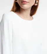 Blusa color lila confeccionada en crepé, con escote redondo y mangas largas con puños elásticos.