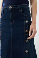 Maxi falda de jean azul oscuro, con tajos y botones dorados.