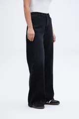 Pantalón de jean negro de corte amplio y relajado, con tiro alto y calce holgado.